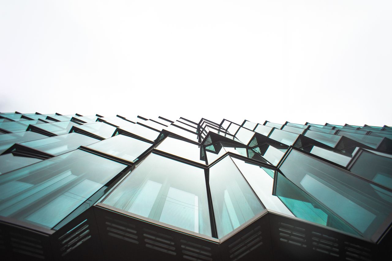 Home Low angle view of a modern building's glass facade, showcasing architectural design.